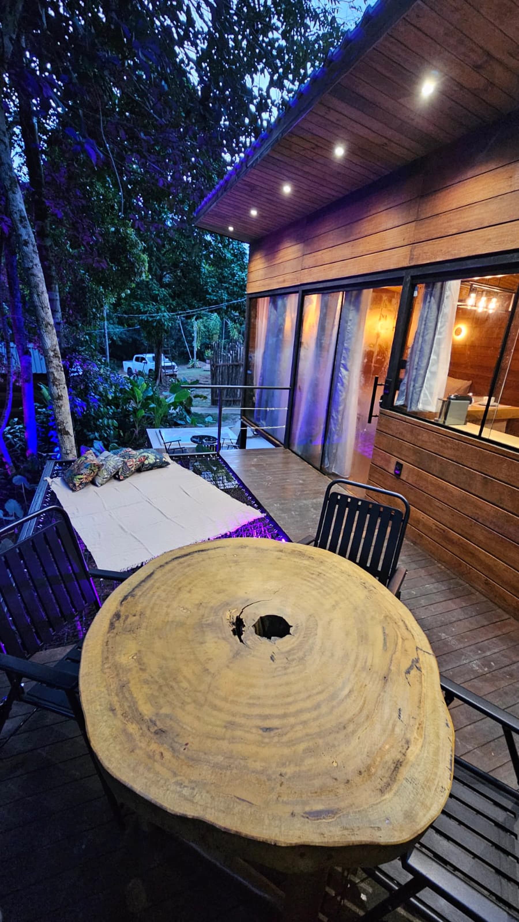 Deck exclusivo iluminado do chalé entre a floresta